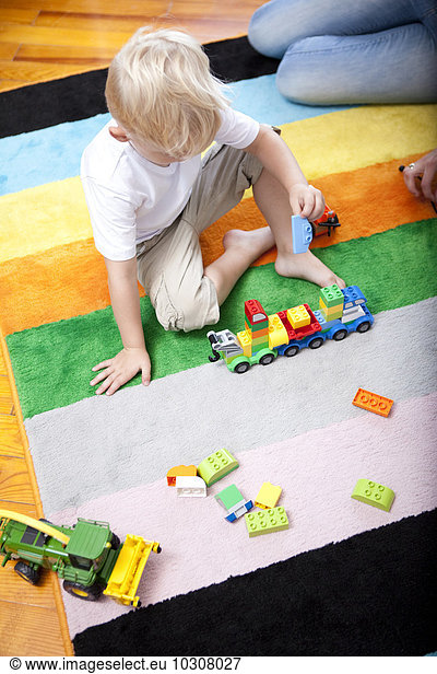 Little boy playing on the carpet of children's room