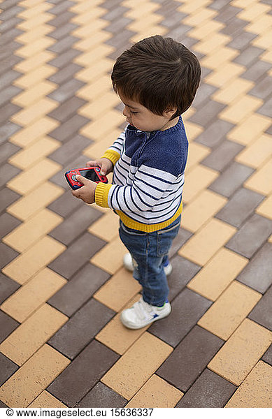 Little boy playing with toy mobile phone