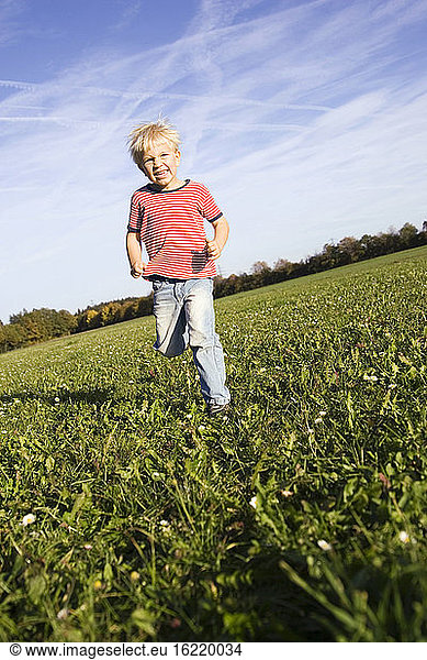 Little boy (4-5) running across meadow