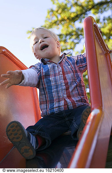 Little boy (2-3 sitting on shute