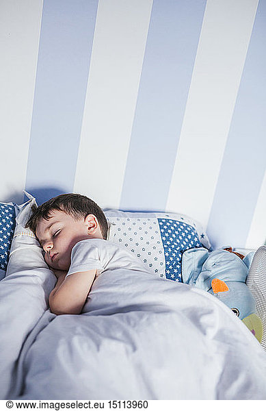 Little boy sleeping on bed in the morning