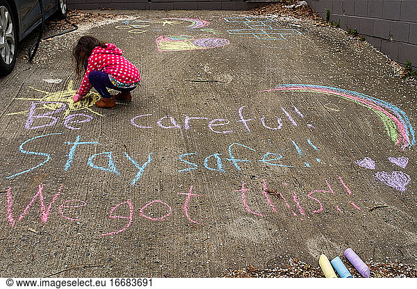 little girl coloring with chalk social distancing encouragement