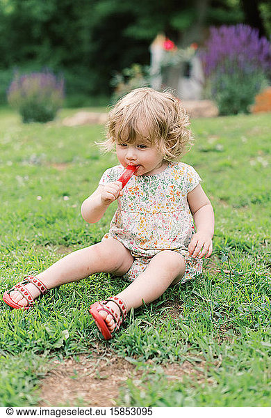 Little girl eating a popsicle.