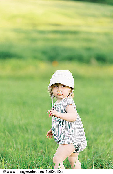 Little girl exploring a meadow.
