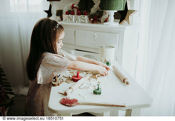 Little girl in glamour dress playing with dough.