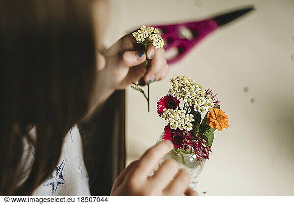 Little Girl makes a flower bouquet in kitchen