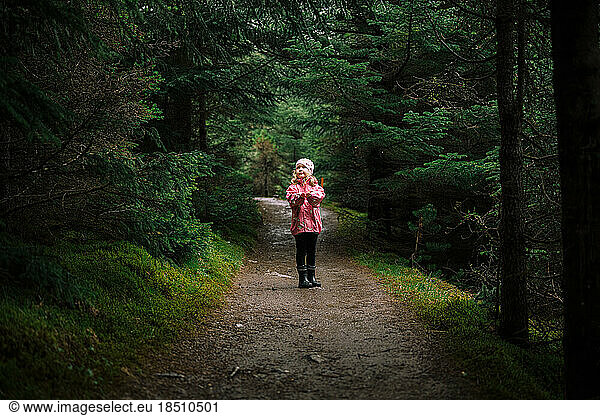 Little girl on mysterious forest trail