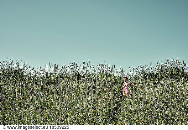 Little girl on serene green field in Iceland