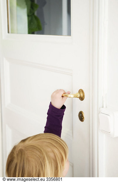 Little girl opening door
