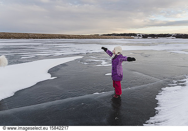 Little Girl Plays on Frozen Lake