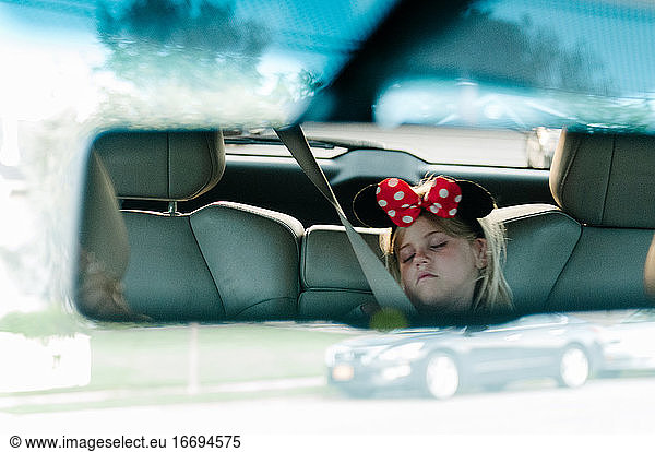Little girl reflection from rearview mirror in car