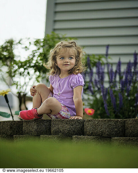 Little girl smiling in flower garden
