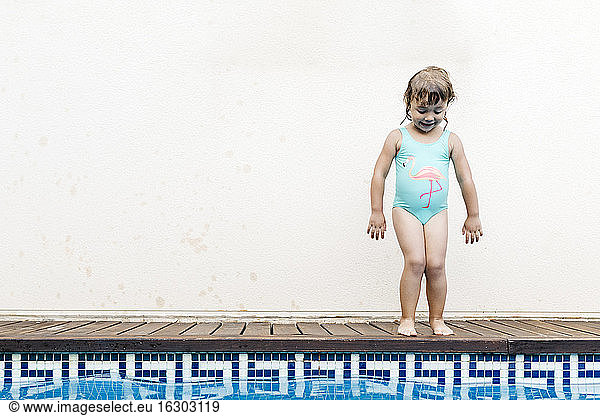 Little girl standing at pool edge