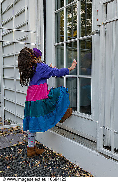 Little girl waiting at door with face mask  impatient
