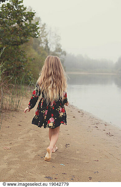 Little girl wanders alone through the fog