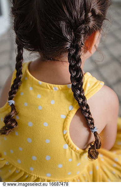 Little girl with braids in yellow dress