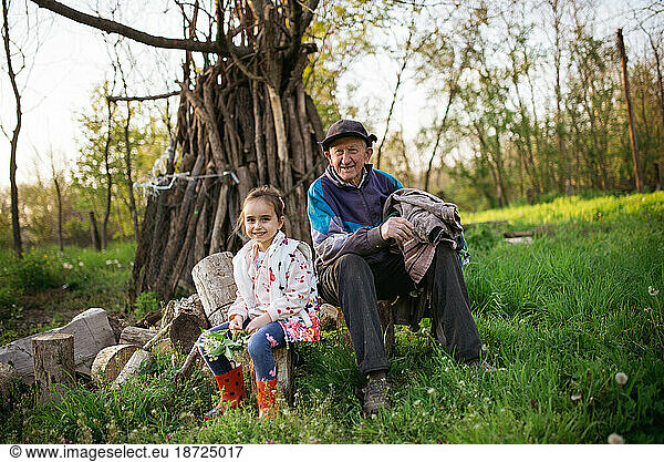 Little girl with her great grandfather laughing and looking at camera.