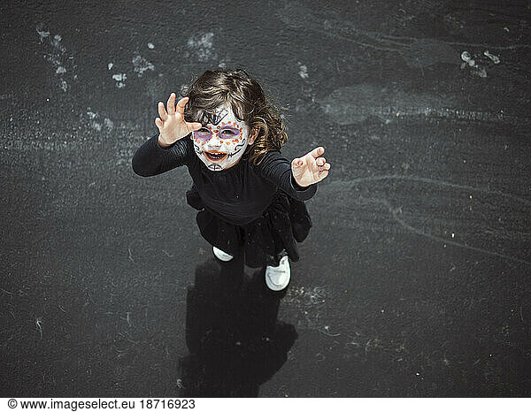 Little girl with painted face looking up