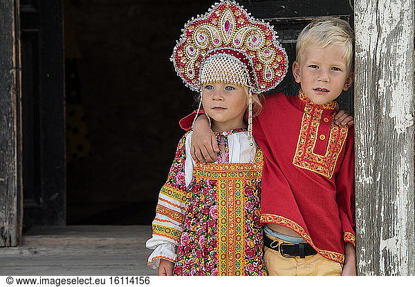 Little Russian girl and her brother in the town of Uglish in traditional dress at a village party