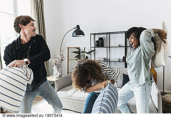 Lively family having fun with a pillow fight at home