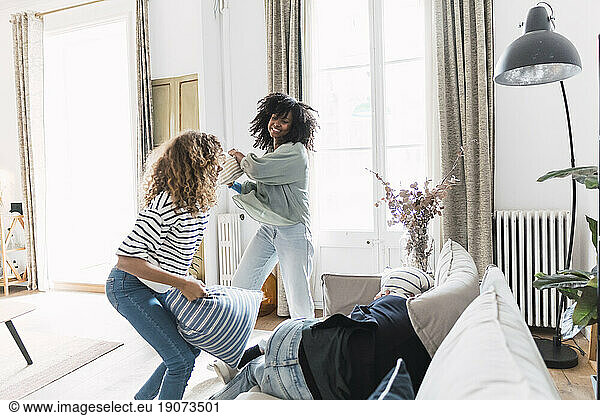 Lively family having fun with a pillow fight at home