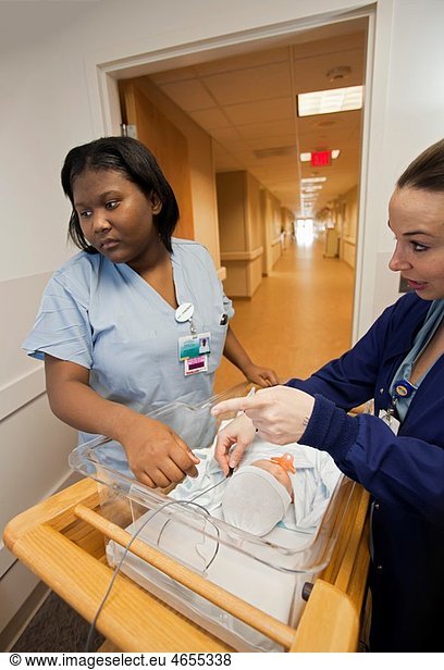 Livonia  Michigan - Briclyn Bailey left  a student from Cristo Rey High School  works in the birthing center at St Mary Mercy Hospital Using a baby mannequin  Tanya Giroux teaches Bailey how to conduct a hearing test on a newborn The Cristo Rey program