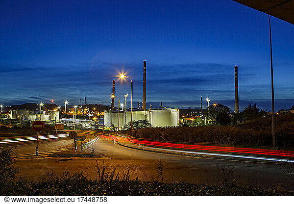 lluminated petrochemical plant against sky during sunset