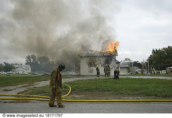 Local fire fighters use a controlled burning of a house for practice; Palmyra  Nebraska  United States of America
