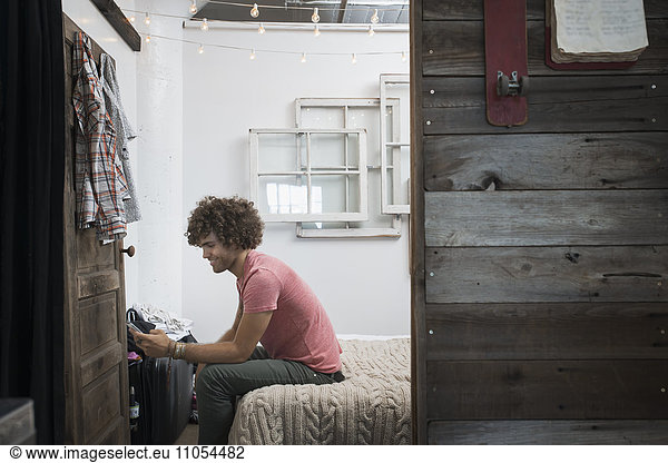 Loft-Wohnen. Ein junger Mann mit einem Smartphone.