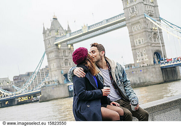 London  United Kingdom. A couple of boy and girl sitting next to Tower Bridge