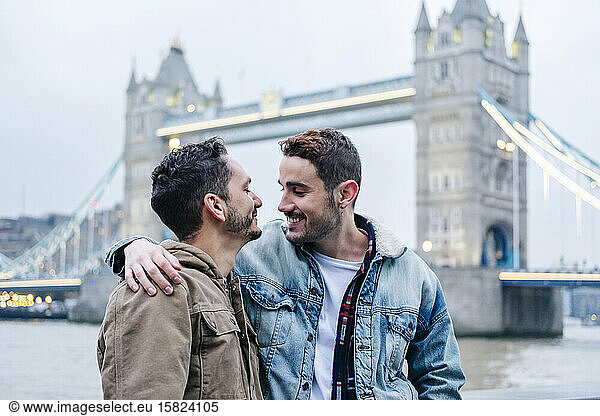 London  United Kingdom  A couple of guys embracing in front of Tower Bridge