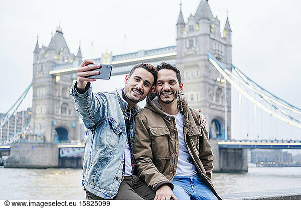 London  United Kingdom  A couple of guys taking selfie in front of Tower Bridge