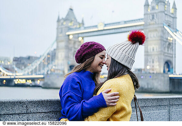 London  United Kingdom. A couple of two girls embracing in front of Tower Bridge