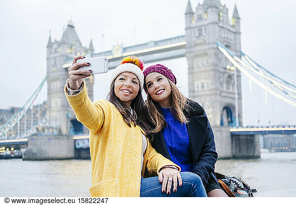 London  United Kingdom  Girlfriends taking selfie in front of Tower Bridge