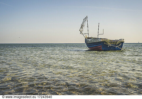Lone fishing boat left on shore of Baltic Sea