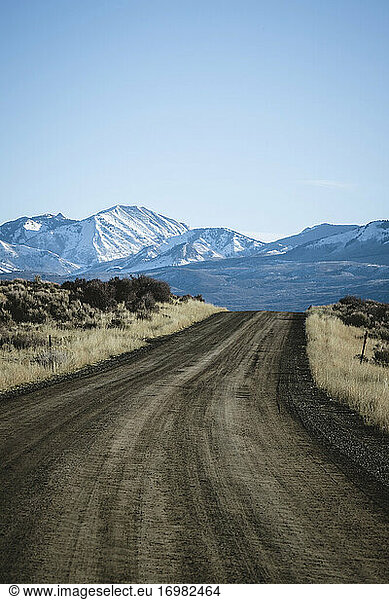 lonely dirt road leading snow capped mountains Black Canyon Colorado