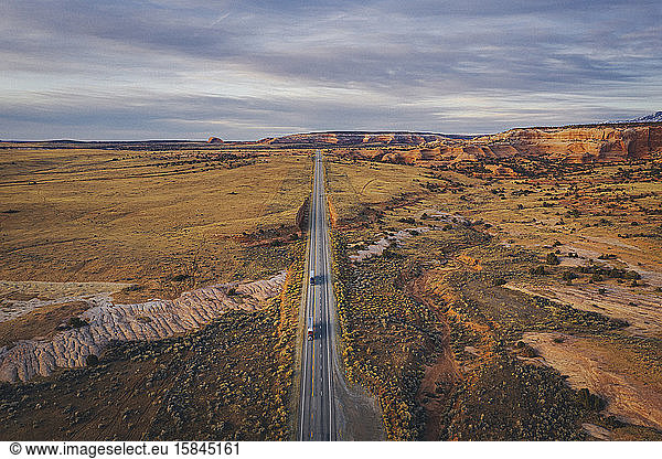 Lonely Utah's road in the evening with trucks from above