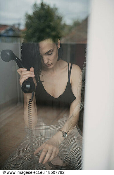 Lonely woman holdidng a telephone receiver.