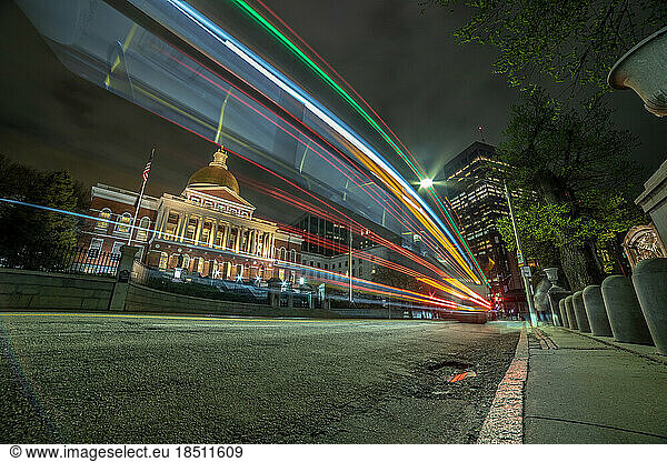 Long exposure bus lights passing in front of State House building.