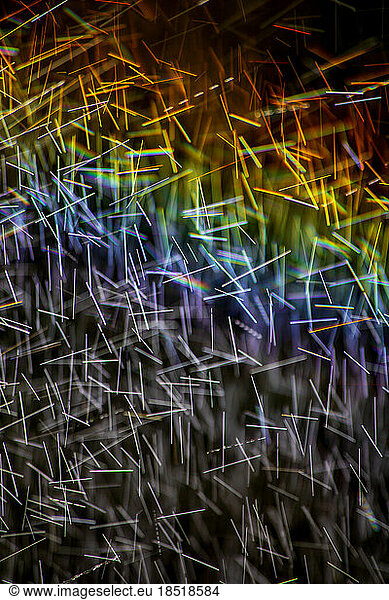 Long exposure of spray of water covered in rainbow colored light