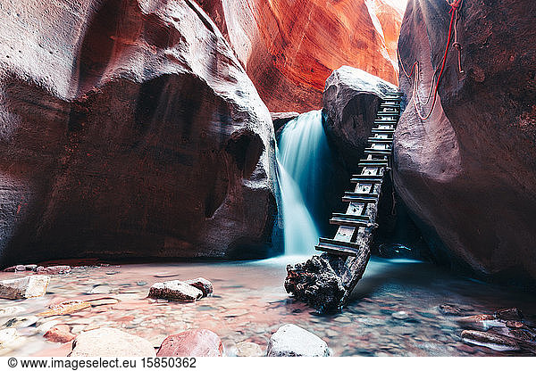 Long exposure of waterfall flowing over rock step in slot canyon