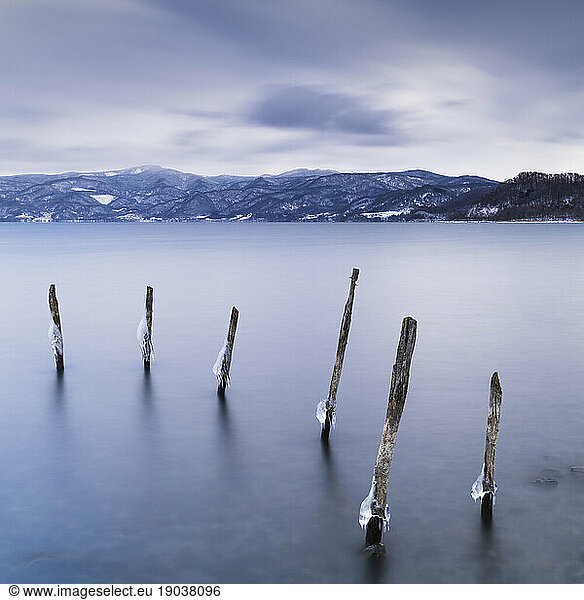 Long exposure shot of wooden sticks in the water at lake Toya  Hokkaido  Japan