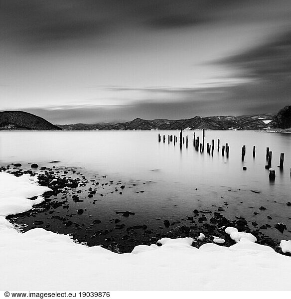 Long exposure shot of wooden sticks in the water at lake Toya  Hokkaido  Japan