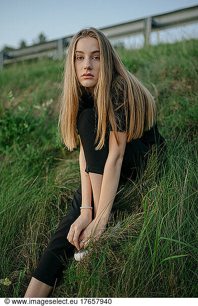 long-haired woman sitting on the grass
