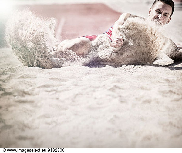 Long jumper landing in sand