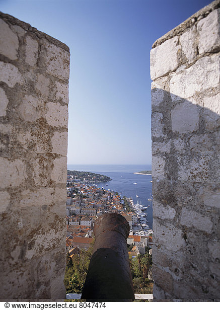 Looking Along Old Cannon In The Citadel To The Harbourfront And Town Of Hvar  Hvar  Croatia. . © Ian Cumming / Axiom