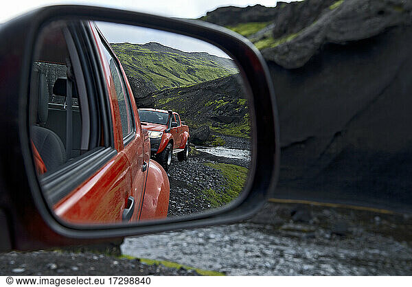 looking at modified pick up truck through rear view mirror