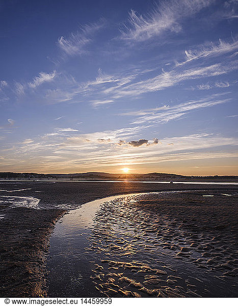 Looking at the setting sun across the Exe estuary towards Starcross from Exmouth Devon England United Kingdom