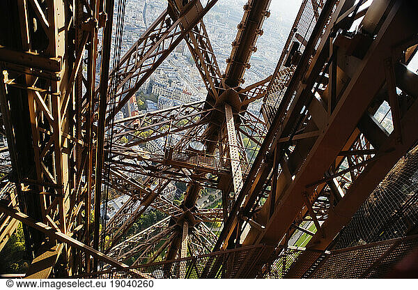 Looking down at the metal structure of the Eiffel Tower.