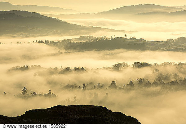 Looking down into the Hawkshead Valley above valley mist formed by a temperature inversion on Loughrigg  near Ambleside in the Lake District National Park.